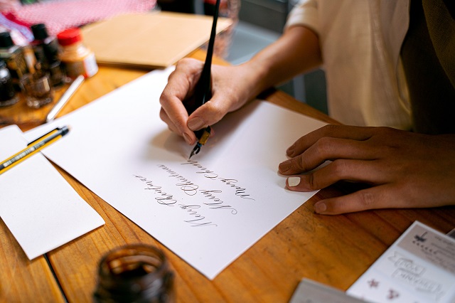 woman writing calligraphy on a paper