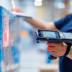 person in a blue shirt using barcode reader