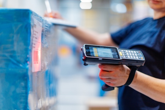 person in a blue shirt using barcode reader 