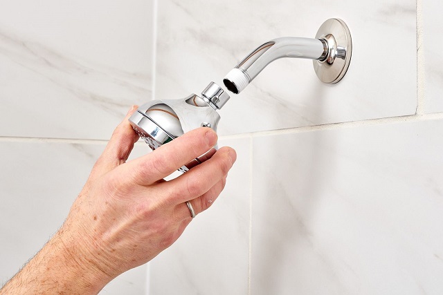 man putting on a new shower head