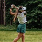 a woman playing golf on a course