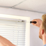 man installing curtains